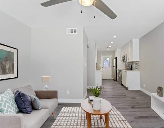 A living room with a couch, a coffee table, and a television.