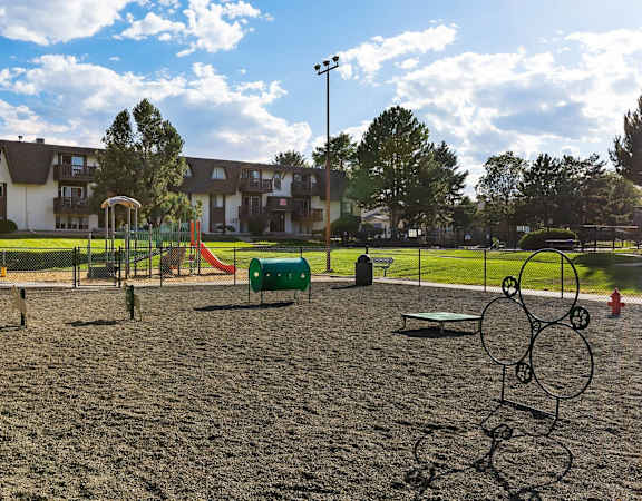 A playground with a sandy area and a swing set.