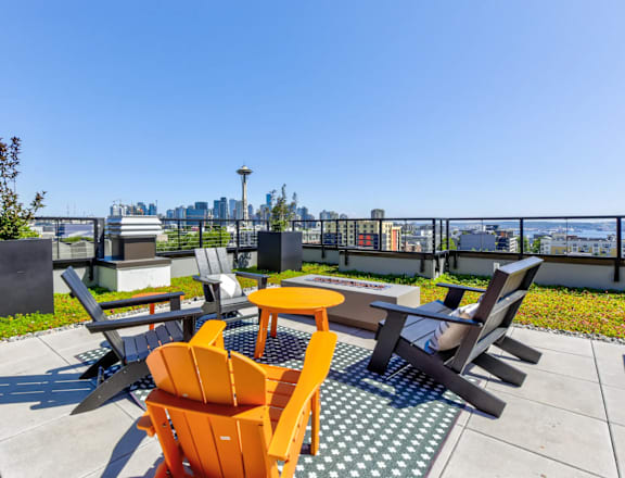 a rooftop patio with chairs and tables and a view of the city