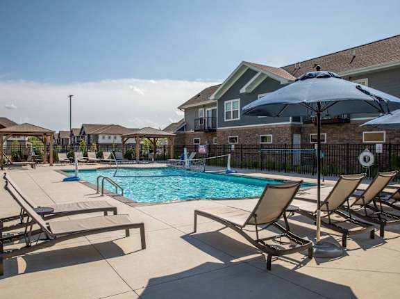 A pool surrounded by chairs and umbrellas.at The Edison at Spirit, Lakeville, MN 55044