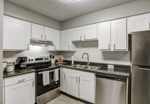 a kitchen with stainless steel appliances and white cabinets
