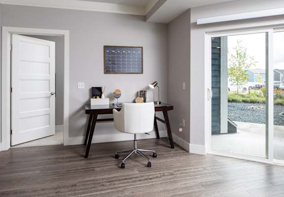 A room with a desk and chair in it.