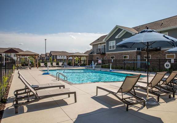 A pool surrounded by chairs and umbrellas.at The Edison at Spirit, Minnesota, 55044