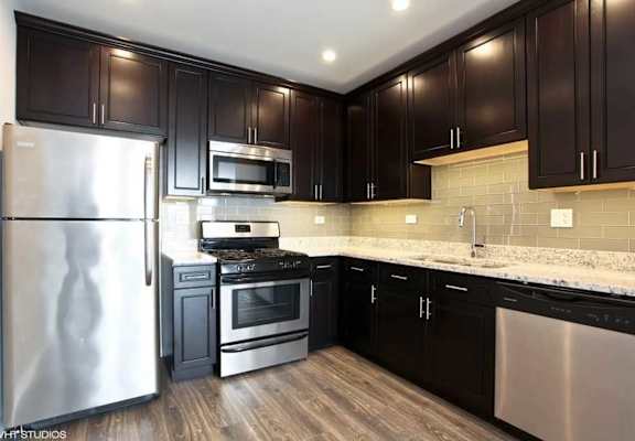 a kitchen with stainless steel appliances and black cabinets