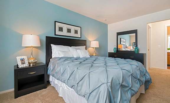 a bedroom with a blue wall and a bed