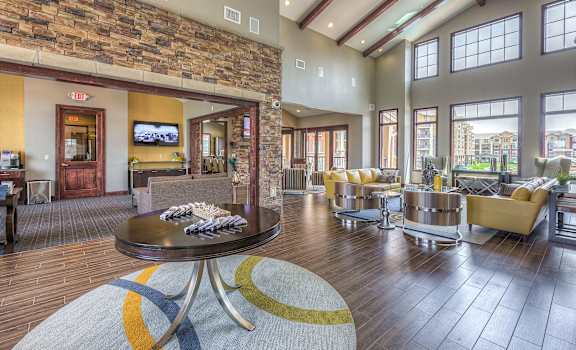 the lobby of a building with a large living room with couches and a table at WaterCrest at City Center, Lenexa, KS, 66219