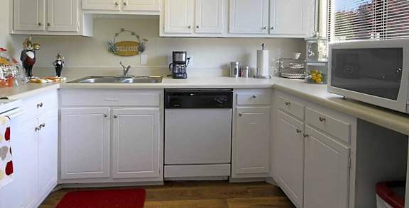 A kitchen with white cabinets and appliances.at Ridgewood Apartments, Greensboro
