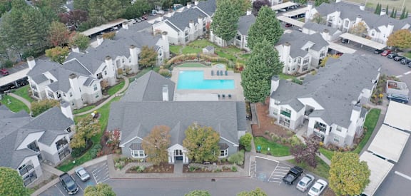 A bird's eye view of a residential area with houses and a swimming pool.