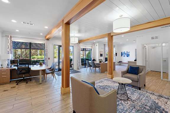 A spacious living room with a large window and a view of trees.