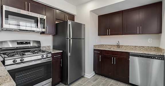 A kitchen with a stove, refrigerator, and cabinets. at Chatham Hill, New Jersey, 07928