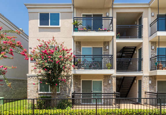 This is a photo of building exteriors and the grounds at The Summit at Midtown Apartments in Dallas, TX.