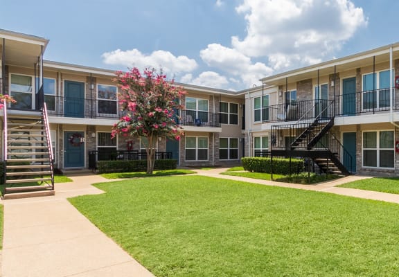 This is a photo of building exteriors and the grounds at The Summit at Midtown Apartments in Dallas, TX.