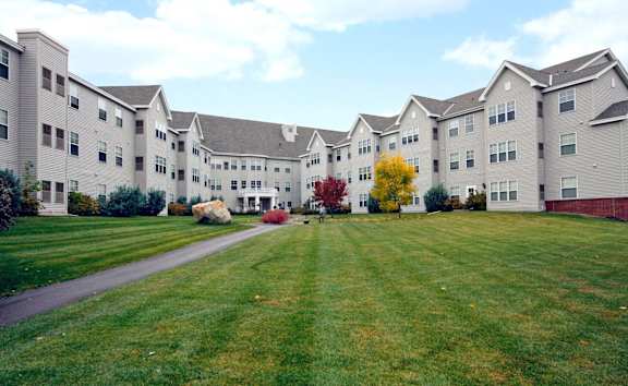 A large grassy area in front of apartment buildings.