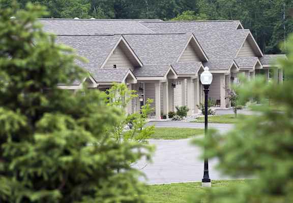 A house with a grey roof and a lamp post in front.
