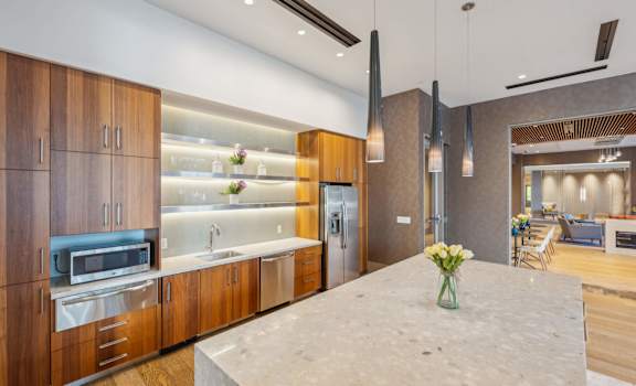 A modern kitchen with wooden cabinets and a marble countertop.