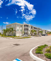 an empty parking lot in front of swiftwater apartment building with palm trees in port charlotte fl