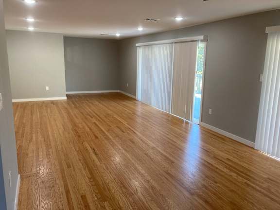 a living room with a wood floor and a sliding glass door