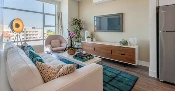 a living room with a white couch and a television