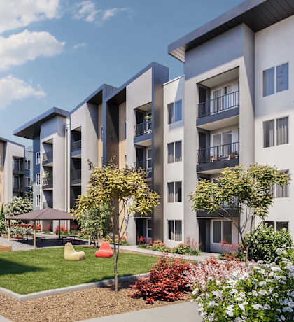 A row of modern apartment buildings with a landscaped garden in the foreground.