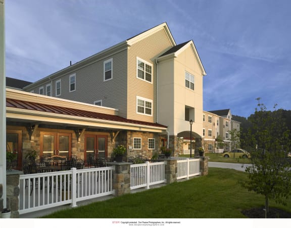a rendering of an apartment building with a white fence