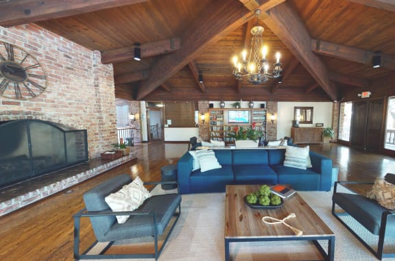 the living room has a large brick fireplace and couches at The Meadows Apartments, California