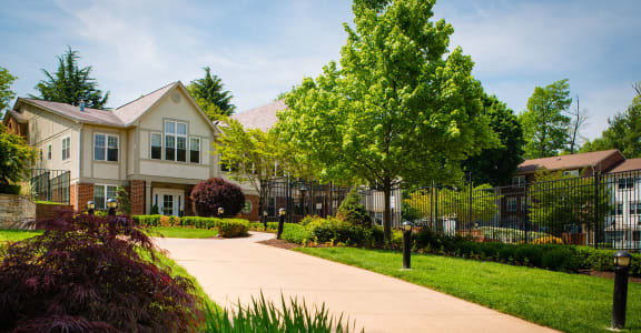 Exterior view of clubhouse of Amberleigh apartments and townhomes with walkways and surrounded by trees and greenery in Fairfax, Virginia 22031