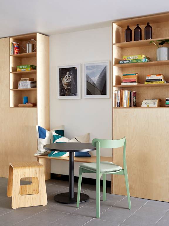 a dining room with a table and two green chairs
