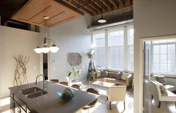 A modern kitchen with a wooden ceiling and a large island with a sink.