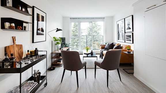 A modern kitchen with a bar area and two chairs.