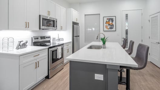 a kitchen with white cabinets and stainless steel appliances
