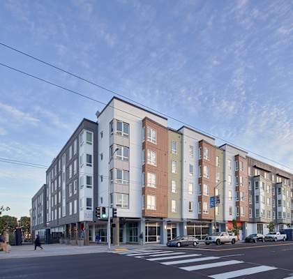 a large apartment building on the corner of a city street