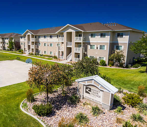 A view of a Shelby Village apartment complex with a playground and a sign.