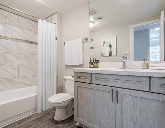 Elegant bathroom with a marble-tiled shower, modern vanity, and soft neutral tones.