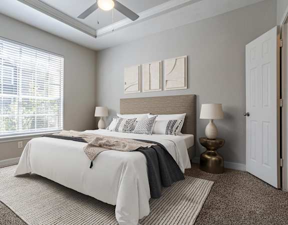 Elegant bedroom featuring a large window, soft neutral tones, and contemporary furnishings.