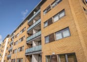 Thumbnail 1 of 6 - a brick building with balconies and a blue sky