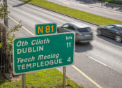 Thumbnail 2 of 6 - a road sign on a highway with cars on it