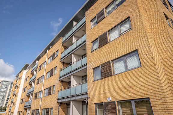 a brick building with balconies and a blue sky