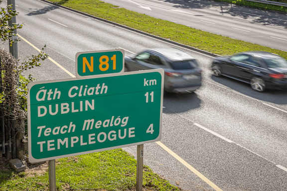 a road sign on a highway with cars on it