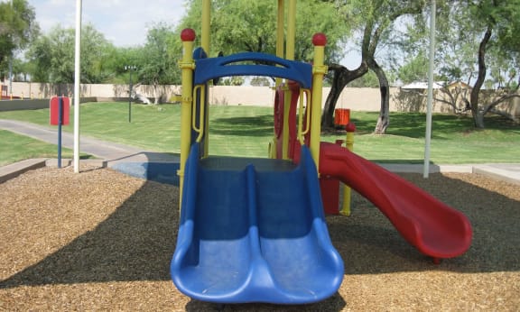 a playground with a blue slide and a red slide