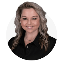 A woman with blonde hair and a black shirt is smiling.