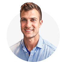 A man with short hair and a blue shirt is smiling.