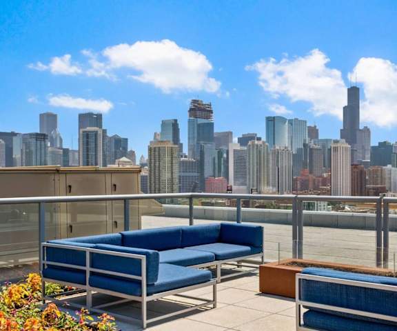 the skyline of the city from a rooftop patio with blue couches