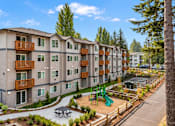 Thumbnail 8 of 8 - Apartment complex with a playground in the front.
