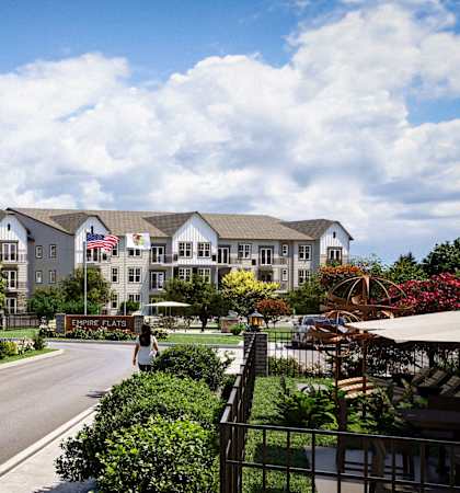 A street view of a residential area with houses and cars.