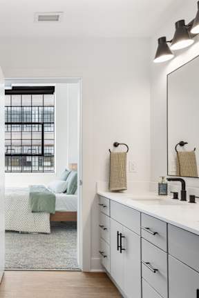 A bathroom with a white countertop and a white toilet.