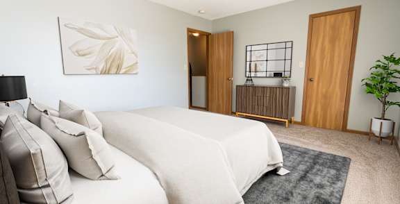A bedroom with a large bed and a painting on the wall.