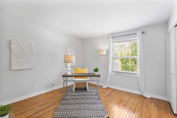 Spacious flex room at Monon Living with hardwood floors and natural light, ideal for a home office or guest space near the Monon Trail in Broad Ripple.