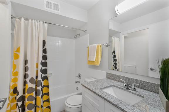 Stylish full bathroom at Monon Living in Broad Ripple featuring granite vanity, designer lighting, and modern tile just minutes from Monon Trail access.