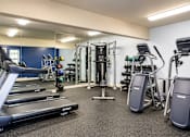 Thumbnail 7 of 8 - A gym with a treadmill, weights, and exercise equipment.