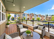 Thumbnail 1 of 8 - A balcony with a table and chairs overlooking a row of houses.
